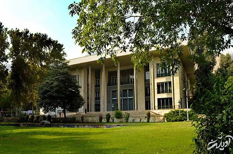 نمایی از ورودی کاخ نیاوران در میان درختان باغ نیاوران